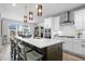 Spacious kitchen with white cabinets, stainless steel appliances, large center island, and seating at 624 Simmental Loop, Castle Rock, CO 80104