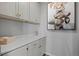 This lovely laundry room features ample white storage cabinets and a quartz countertop at 624 Simmental Loop, Castle Rock, CO 80104