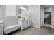 Bathroom showcasing double sinks, gray tile floors, a decorative plant, bench and modern fixtures at 624 Simmental Loop, Castle Rock, CO 80104