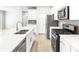 Bright kitchen with white cabinets, quartz countertops, stainless steel appliances and wood floors at 22495 E 7Th Pl, Aurora, CO 80018