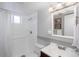 Bathroom with white tile, sleek fixtures, a shower with curtain, and a dark wood vanity at 5132 Eaton St, Denver, CO 80212