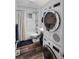 Efficient bathroom with a stackable washer-dryer, modern fixtures, and a shower-tub combination at 5132 Eaton St, Denver, CO 80212