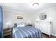 Cozy bedroom with hardwood floors, a striped bedspread, and contemporary decor at 5132 Eaton St, Denver, CO 80212