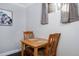 Small dining area features a light wood table, two chairs, and a window with natural light at 5132 Eaton St, Denver, CO 80212