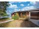 Charming brick home with a well-manicured lawn and an attached garage with brown door at 5132 Eaton St, Denver, CO 80212