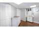 Laundry room offers sink, white cabinets, and dark wood flooring at 5132 Eaton St, Denver, CO 80212