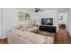 Bright living room featuring hardwood floors, neutral-toned sofas, and a large window with natural light at 5132 Eaton St, Denver, CO 80212