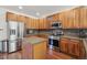 Updated kitchen with stainless steel appliances, wood cabinetry, and a central island with granite countertops at 4321 W 118Th Pl, Westminster, CO 80031