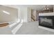 Open-concept living area with a fireplace, neutral carpet, and open access to the staircase and kitchen at 4321 W 118Th Pl, Westminster, CO 80031