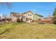 Spacious backyard with lawn, patio, trampoline, and mature trees, perfect for outdoor activities at 6126 S Pierson St, Littleton, CO 80127