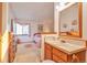Bright, neutral bathroom adjoining bedroom featuring vanity with sink, medicine cabinet and natural light at 6126 S Pierson St, Littleton, CO 80127