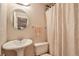 Cozy bathroom has neutral color palette, features pedestal sink and patterned shower curtain at 6126 S Pierson St, Littleton, CO 80127