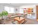 Comfortable living room with a large sectional sofa, open to the dining area, and natural light at 6126 S Pierson St, Littleton, CO 80127