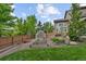 Spacious backyard featuring a charming greenhouse, raised garden beds, and lush greenery at 7408 Sodalite Way, Castle Rock, CO 80108