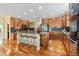 Open kitchen with wooden cabinets, stainless appliances, island with bar seating and hardwood floors at 7408 Sodalite Way, Castle Rock, CO 80108