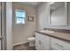 Well-lit bathroom with a white vanity, sink, mirror, and toilet, complemented by gray wood flooring at 2790 Center Park Way, Berthoud, CO 80513