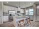 Bright kitchen featuring stainless steel appliances, gray countertops, and a kitchen island with seating at 2790 Center Park Way, Berthoud, CO 80513