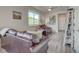 Inviting living room with modern gray wood floors and comfortable brown leather seating beneath a ceiling fan at 2790 Center Park Way, Berthoud, CO 80513