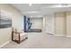 A finished basement featuring neutral carpet, a treadmill, and a cozy seating area by a window at 123 Wheat Ridge St, Palmer Lake, CO 80133