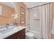A stylish bathroom featuring a marble vanity top, decorative flower arrangement, and a shower-tub combination at 123 Wheat Ridge St, Palmer Lake, CO 80133