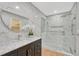 Modern bathroom with white marble tiling, glass enclosed shower, and stylish vanity with a round mirror at 123 Wheat Ridge St, Palmer Lake, CO 80133