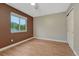 Neutral bedroom with two-toned walls, wood laminate flooring and a large window showing a wooded view at 123 Wheat Ridge St, Palmer Lake, CO 80133