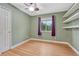 Green bedroom with wood laminate floors, a ceiling fan, white trim and purple drapes at 123 Wheat Ridge St, Palmer Lake, CO 80133