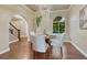 Stylish dining room with a chandelier, arched window, and hardwood floors, adjacent to staircase at 123 Wheat Ridge St, Palmer Lake, CO 80133