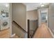 Hallway with a laundry room with a front load washer, a metal railing and wood laminate floors at 123 Wheat Ridge St, Palmer Lake, CO 80133