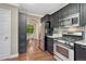 Modern kitchen features black cabinetry, stainless steel appliances, and granite countertops at 123 Wheat Ridge St, Palmer Lake, CO 80133