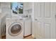 A convenient laundry room with modern washer and dryer, near a sunny window for natural light and ventilation at 123 Wheat Ridge St, Palmer Lake, CO 80133