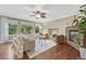 Bright living room featuring hardwood floors, a stone fireplace, and large windows overlooking the yard at 123 Wheat Ridge St, Palmer Lake, CO 80133