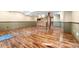 Large finished basement featuring wood floors, a support column and a wet bar with wood cabinets and a microwave at 23060 Hope Dale Ave, Parker, CO 80138