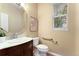 Half bath with dark wood vanity, large mirror, and a window offering natural light at 23060 Hope Dale Ave, Parker, CO 80138