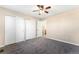 Neutral bedroom with plush carpet, a ceiling fan, and ample closet space with three large sliding door closets at 23060 Hope Dale Ave, Parker, CO 80138