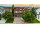 Two-story home with a well-manicured lawn, mature trees, and a driveway leading to a two-car garage at 23060 Hope Dale Ave, Parker, CO 80138