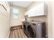 Well-equipped laundry room with modern appliances, storage cabinets, and laminate flooring at 23060 Hope Dale Ave, Parker, CO 80138