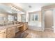 Large main bathroom with double sinks, tub and tile floor with natural light from window with shutters at 23060 Hope Dale Ave, Parker, CO 80138