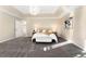 Main bedroom with a tray ceiling, chandelier, soft carpet, and a comfortable bed and bench at 23060 Hope Dale Ave, Parker, CO 80138