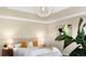Bright main bedroom with tray ceiling, chandelier, and neutral tones, creating a serene atmosphere at 23060 Hope Dale Ave, Parker, CO 80138
