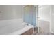 Bathroom showcases a soaking tub with shower, complemented by neutral walls and access to the bedroom at 5124 S Jebel St, Centennial, CO 80015