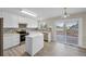 A view of the modern kitchen with island, stainless appliances, and door leading to the outdoor deck at 5124 S Jebel St, Centennial, CO 80015