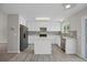 Modern kitchen with white cabinetry, stainless steel appliances, and an island with a white countertop at 5124 S Jebel St, Centennial, CO 80015