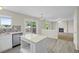 Open concept kitchen with stainless steel appliances, a central island, and easy access to the living room and back deck at 5124 S Jebel St, Centennial, CO 80015