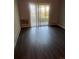 Bright living room with sliding glass doors and dark wood-look floors provides lots of natural light at 665 S Clinton St # 14A, Denver, CO 80247