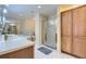 Well-lit bathroom featuring double vanity, shower, toilet, and storage at 7559 S Ivanhoe Cir, Centennial, CO 80112