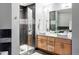 Modern bathroom with dual sinks, stone tile and a glass-enclosed shower at 1440 Little Raven St # 202, Denver, CO 80202