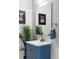 Bright bathroom with modern vanity, fresh paint, decorative wall art, and vibrant green plant at 1440 Little Raven St # 202, Denver, CO 80202