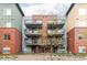 Low-rise condo building with brick and metal exterior and multiple balconies at 1440 Little Raven St # 202, Denver, CO 80202