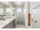 Bright bathroom featuring a double vanity, glass shower and decorative backsplash at 3142 W 20, Denver, CO 80211
